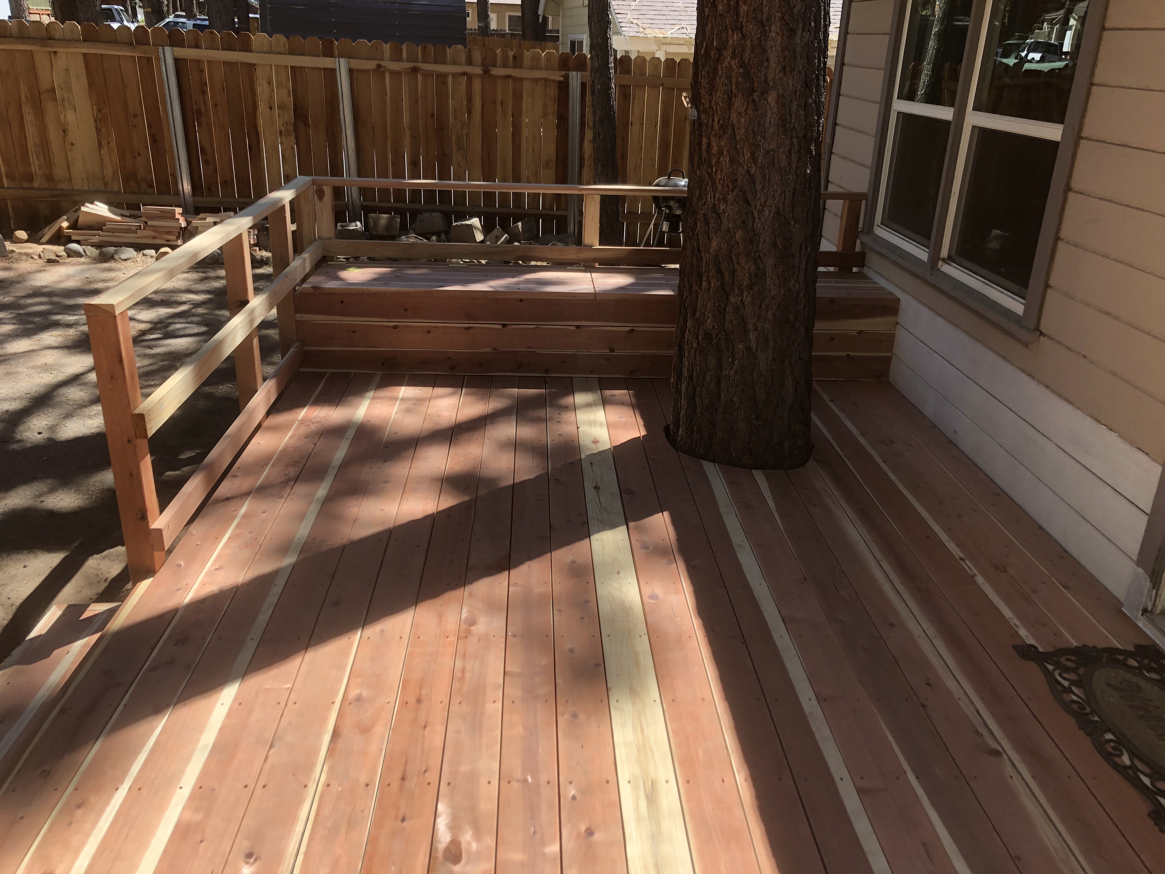 Cedar deck build in progress with tree