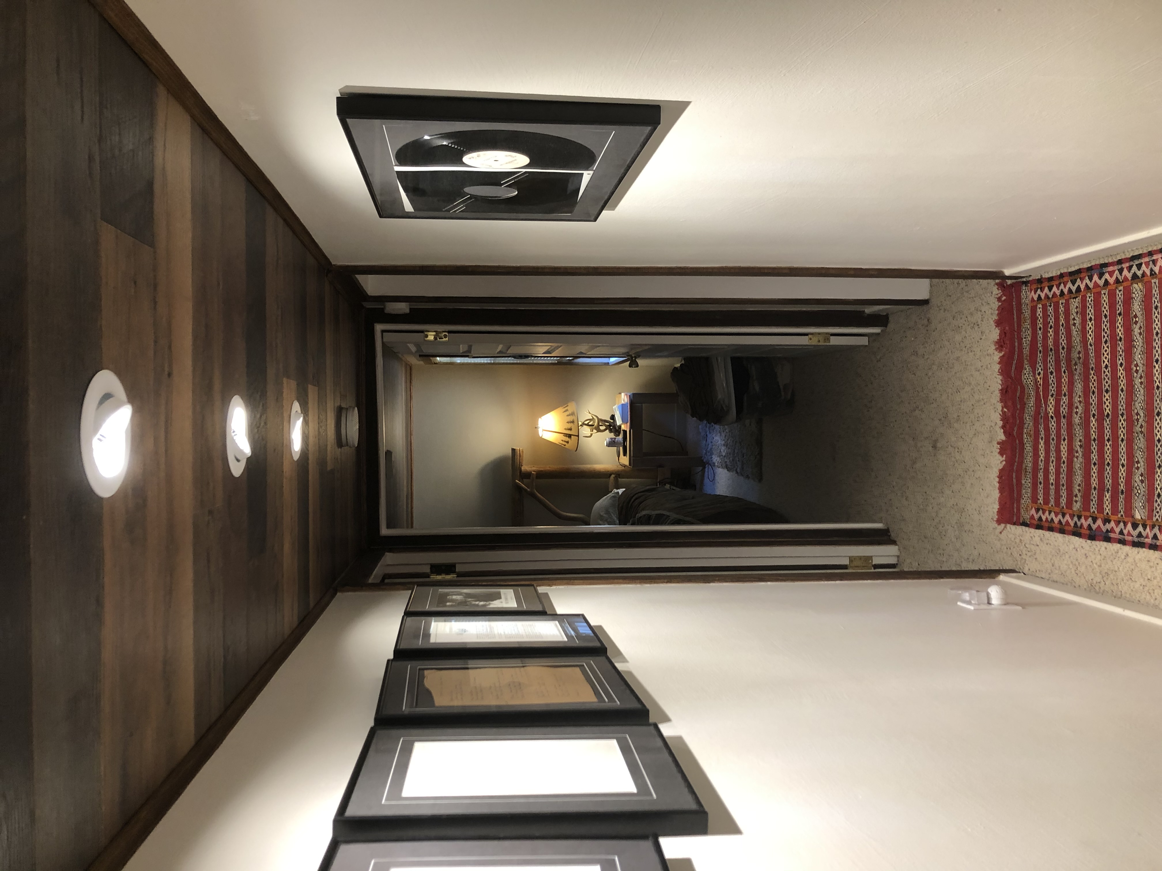 Hallway with wood accent wall and framed photos