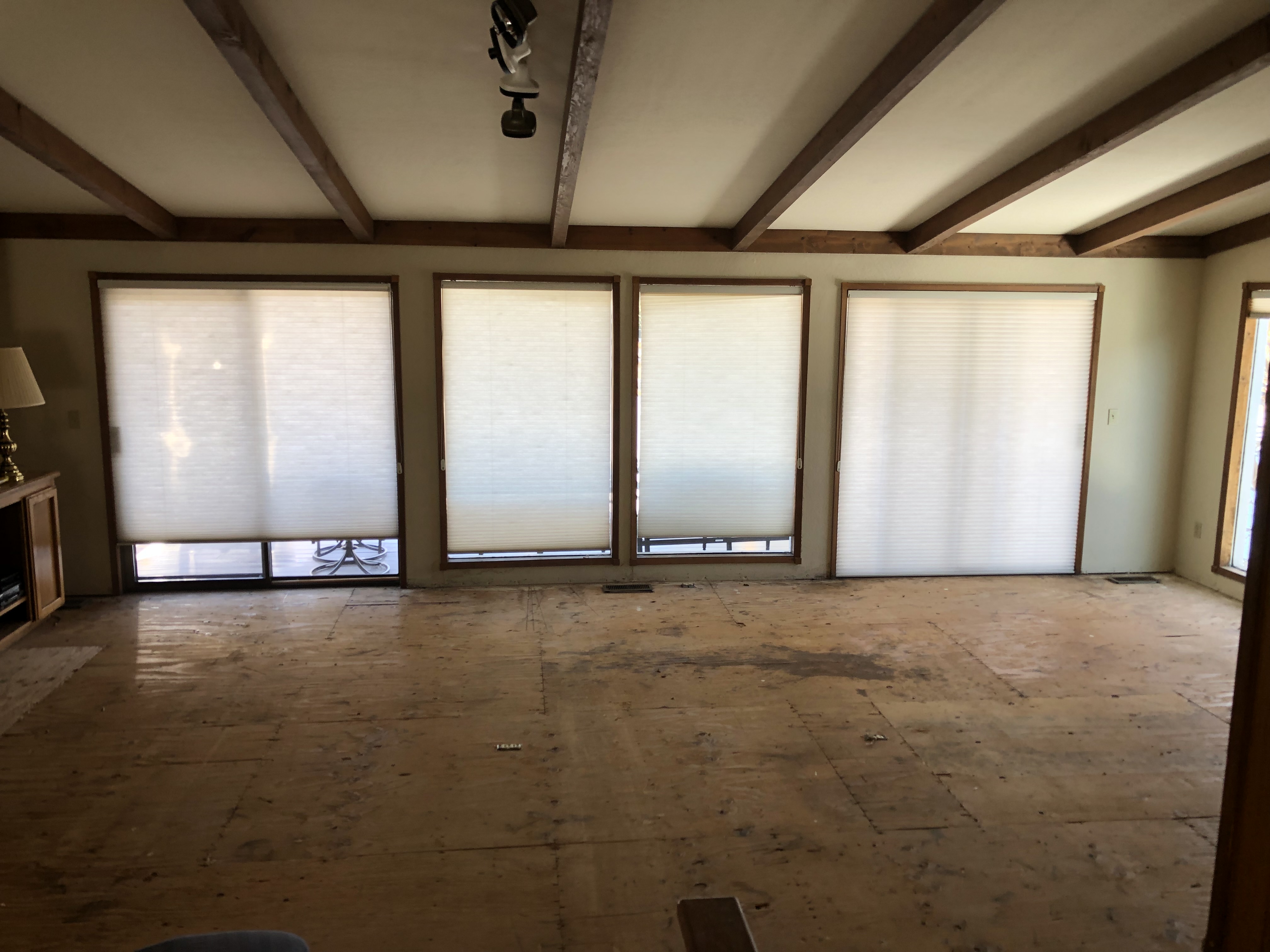 Living room during demolition, bare subfloor and beams
