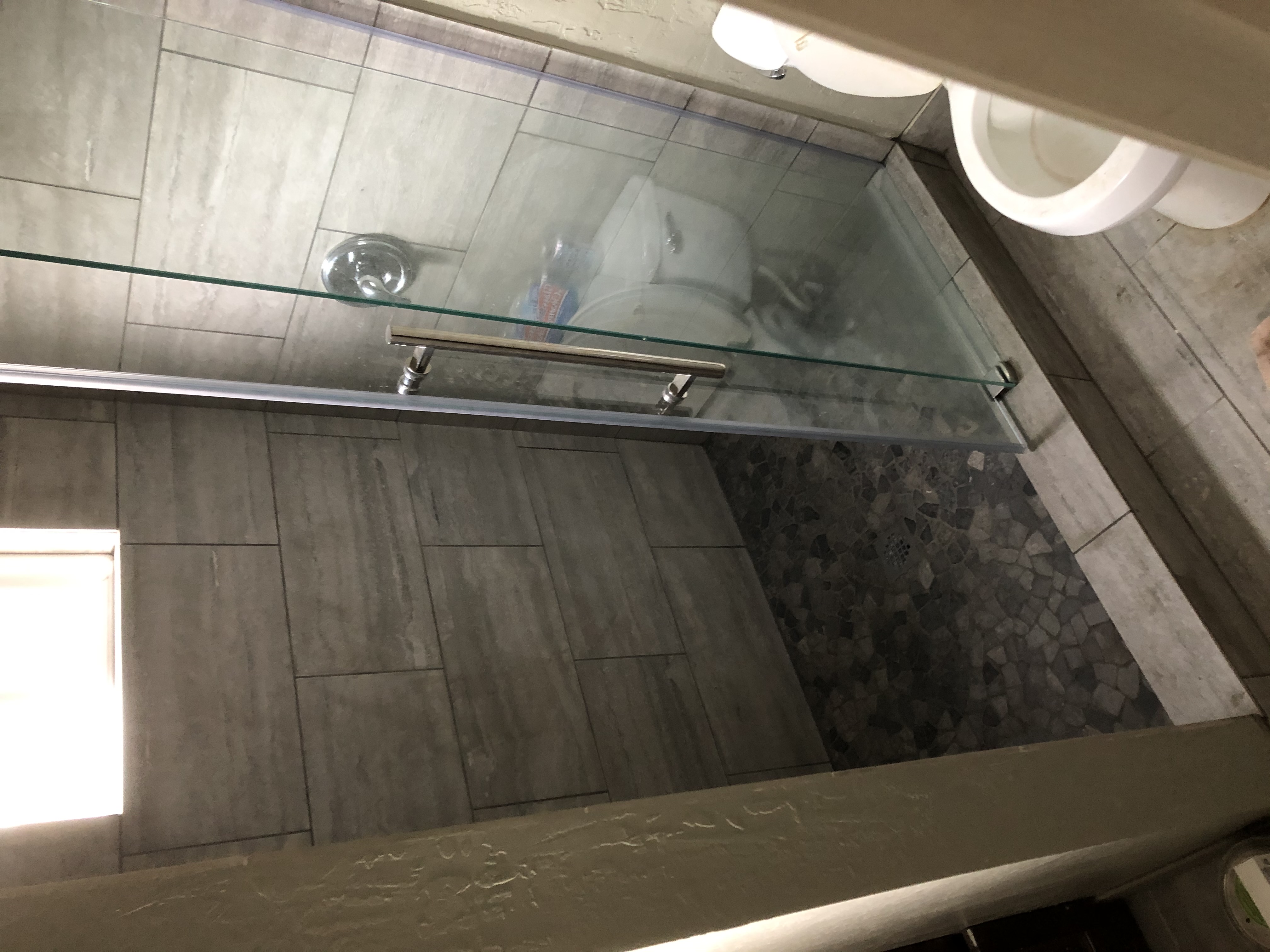 Glass shower with natural stone floor