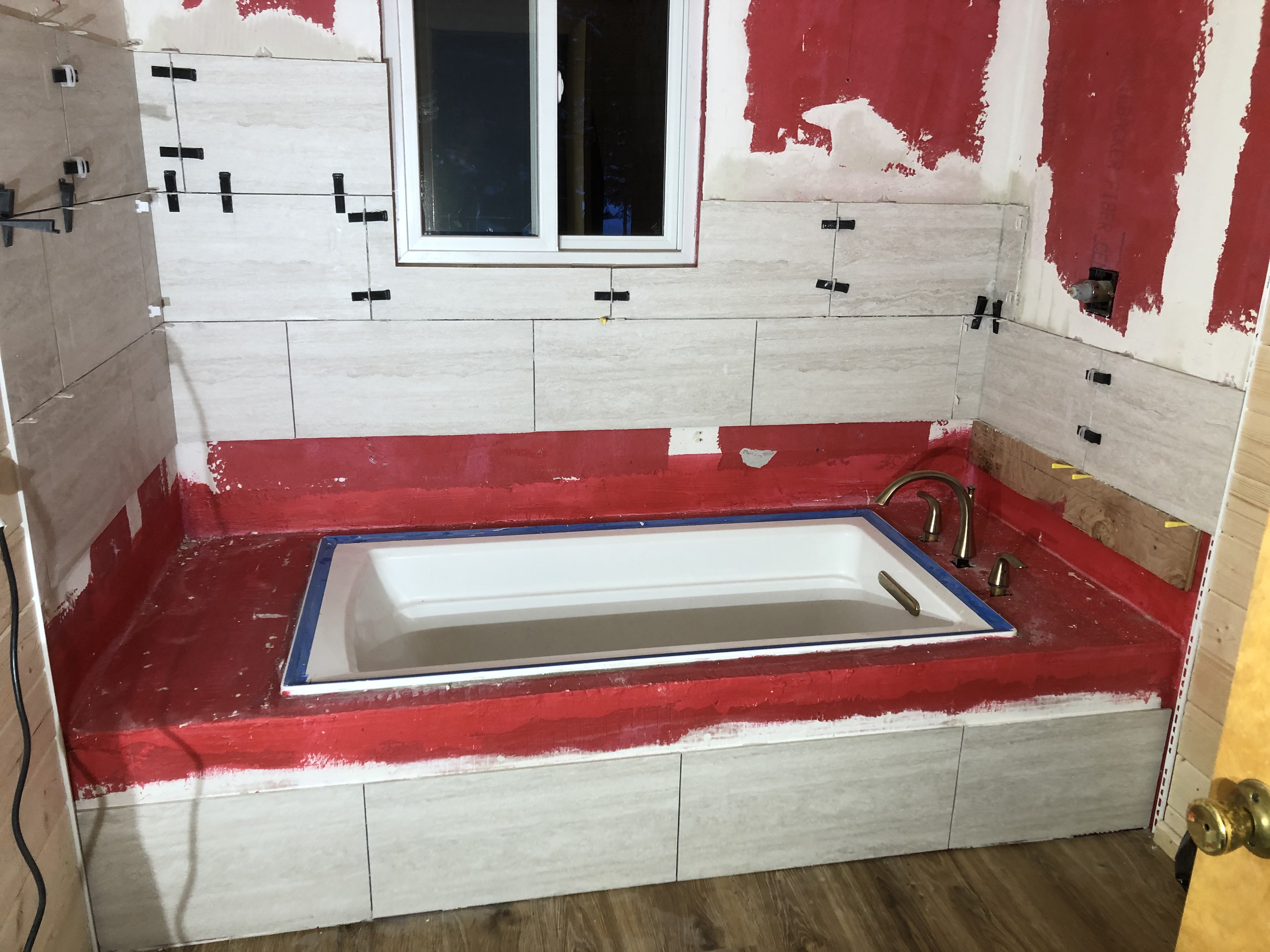 Bathtub area with red waterproofing membrane applied